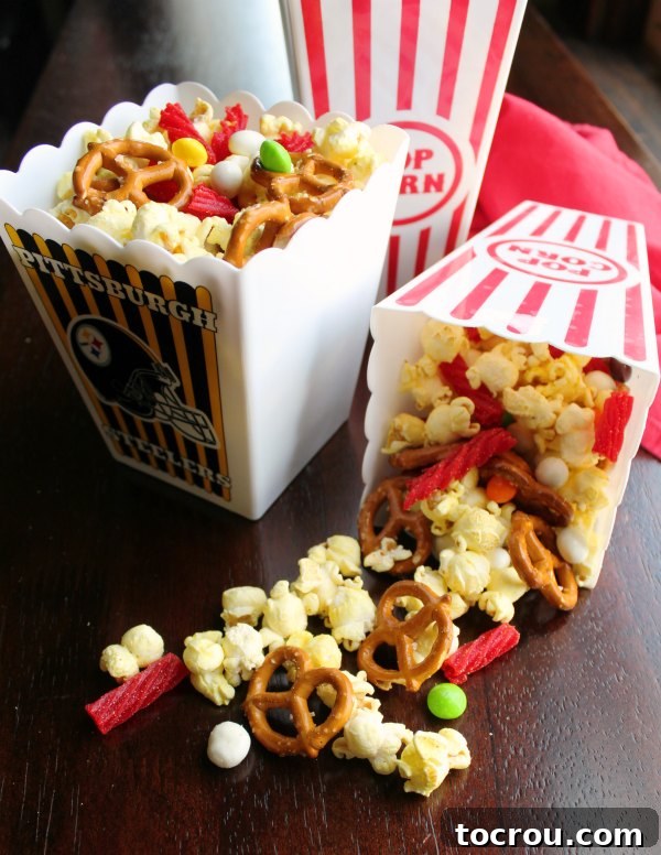 Multiple containers showcasing the movie theater snack mix with popcorn, pretzels, licorice, and other candies, ready for serving.