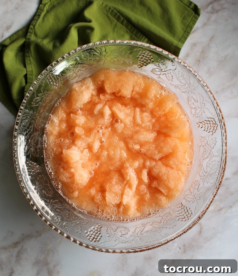 peach slush in glass punch bowl, waiting for soda to be poured in.