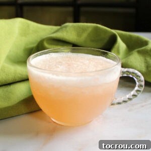 close up of a glass punch mug with slushy peach punch inside.