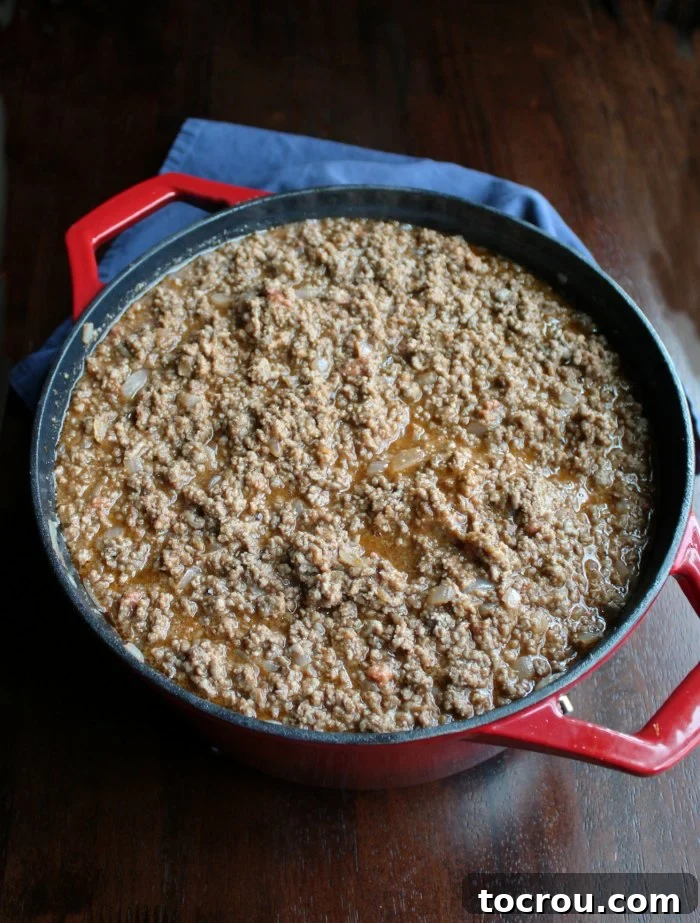 A large cast iron pot filled with freshly cooked sloppy joe meat, ready for serving.
