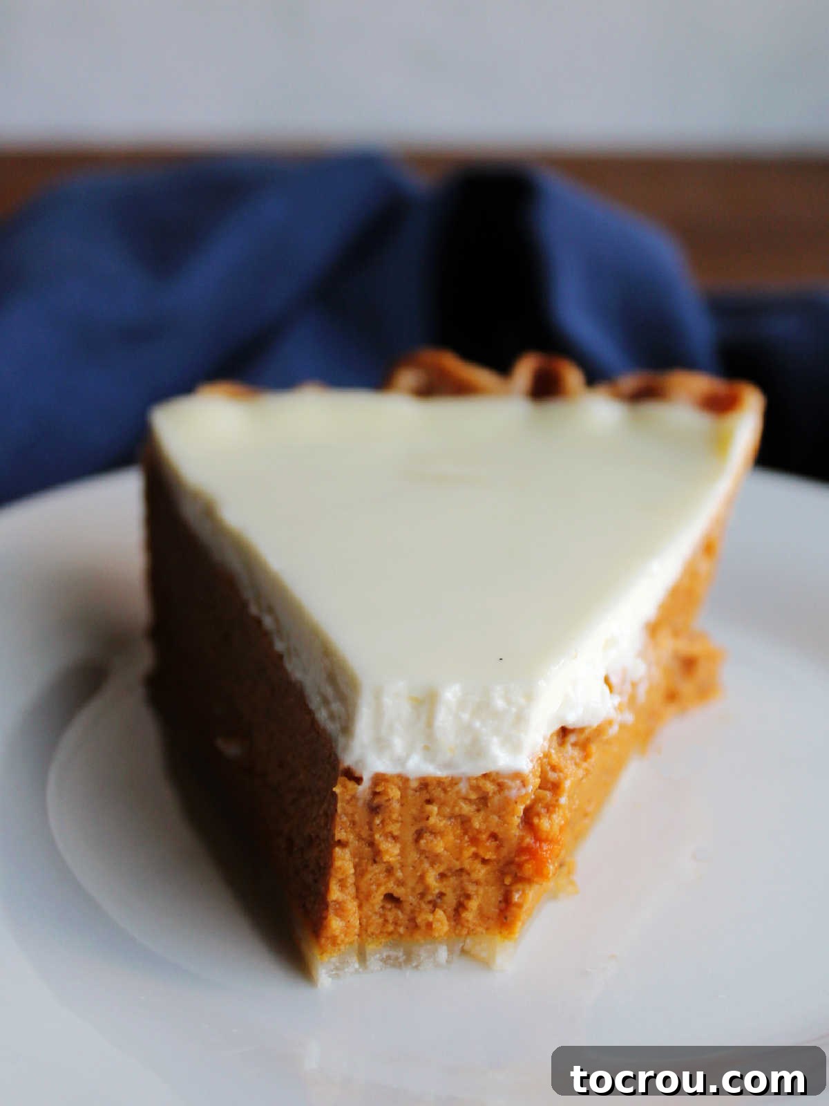 A delectable slice of layered pumpkin pie with a bite missing, showcasing the perfect balance of pumpkin and sour cream layers.