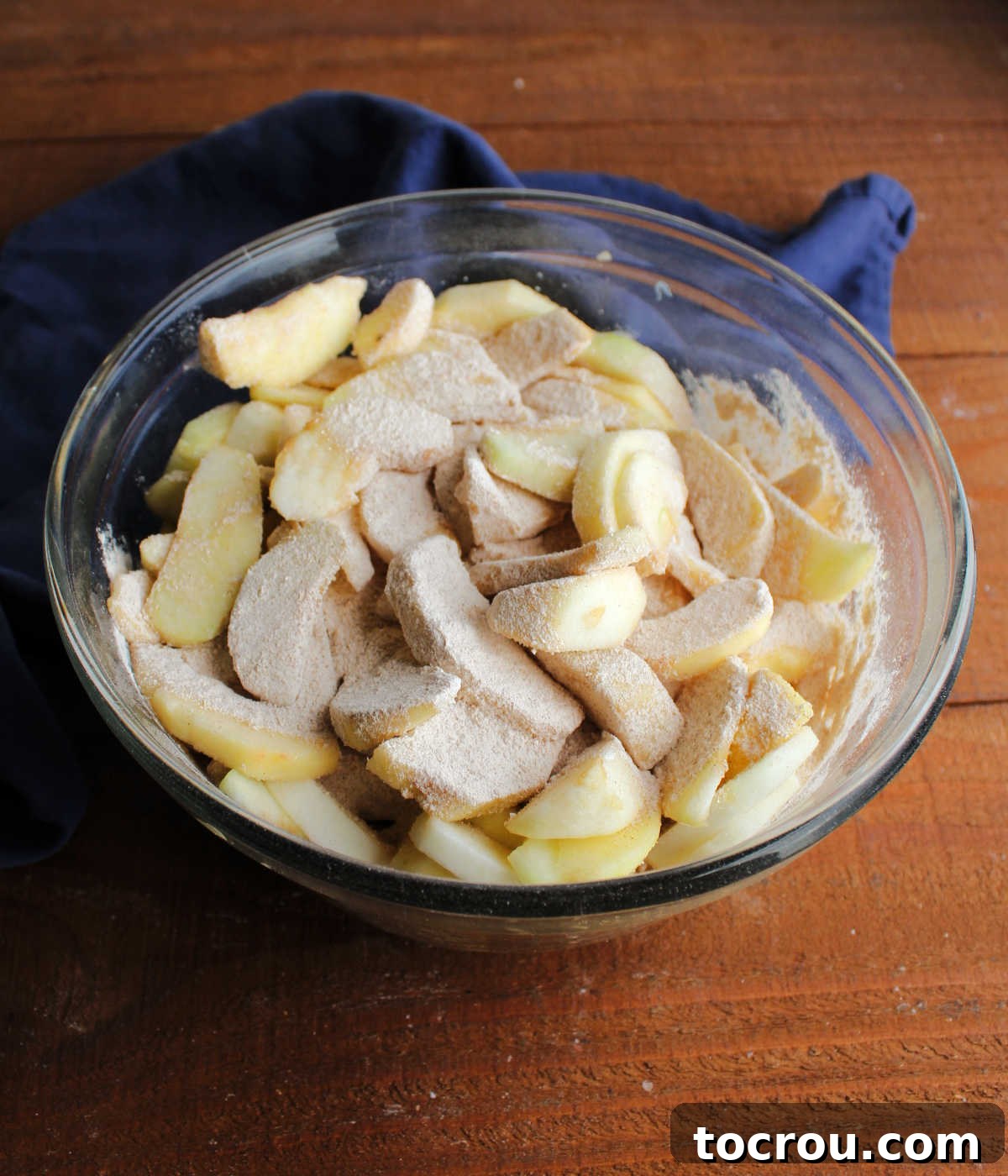 Apples coated in flour and sugar ready to go in pie crust.