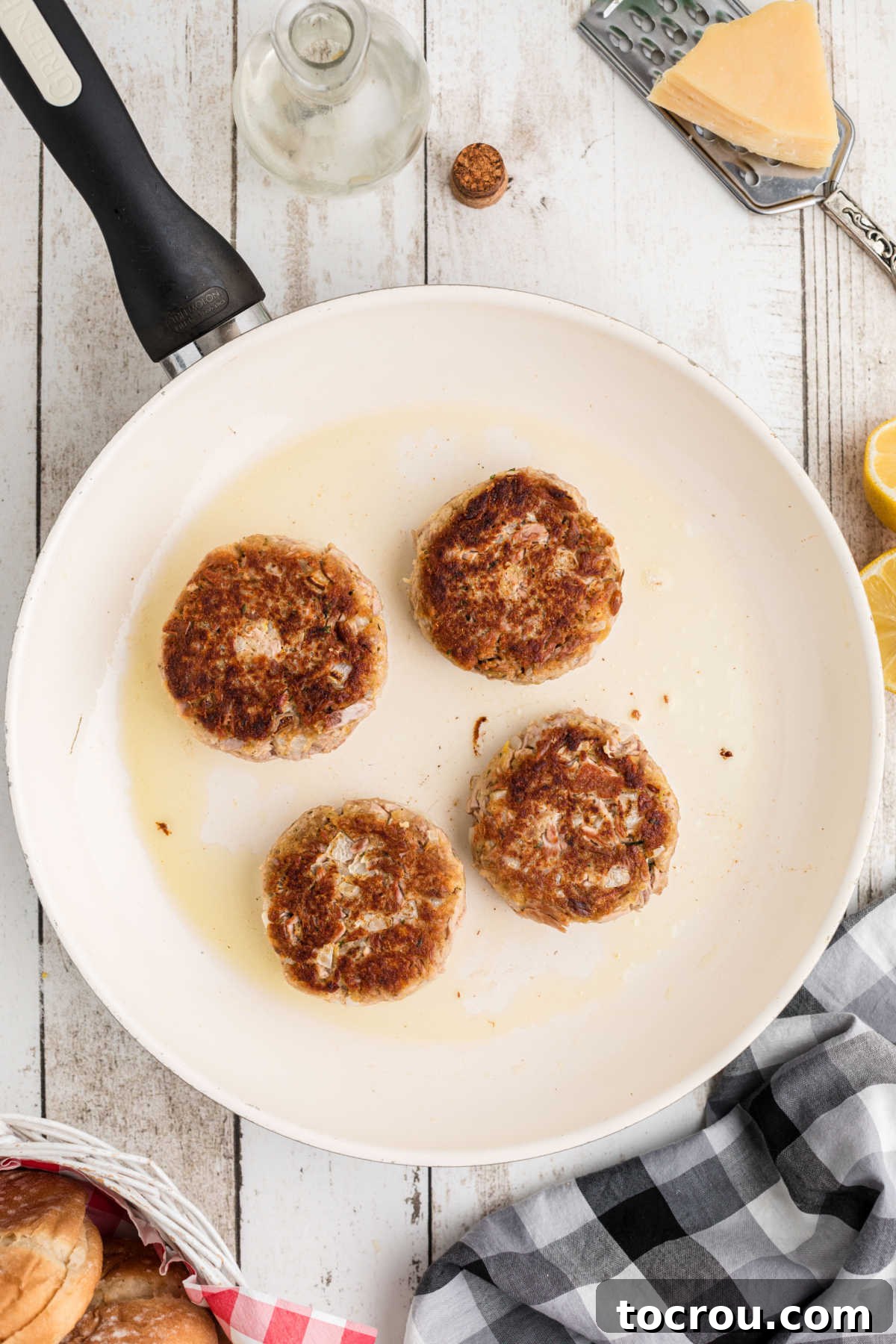 Golden brown tuna patties in skillet after being cooked.