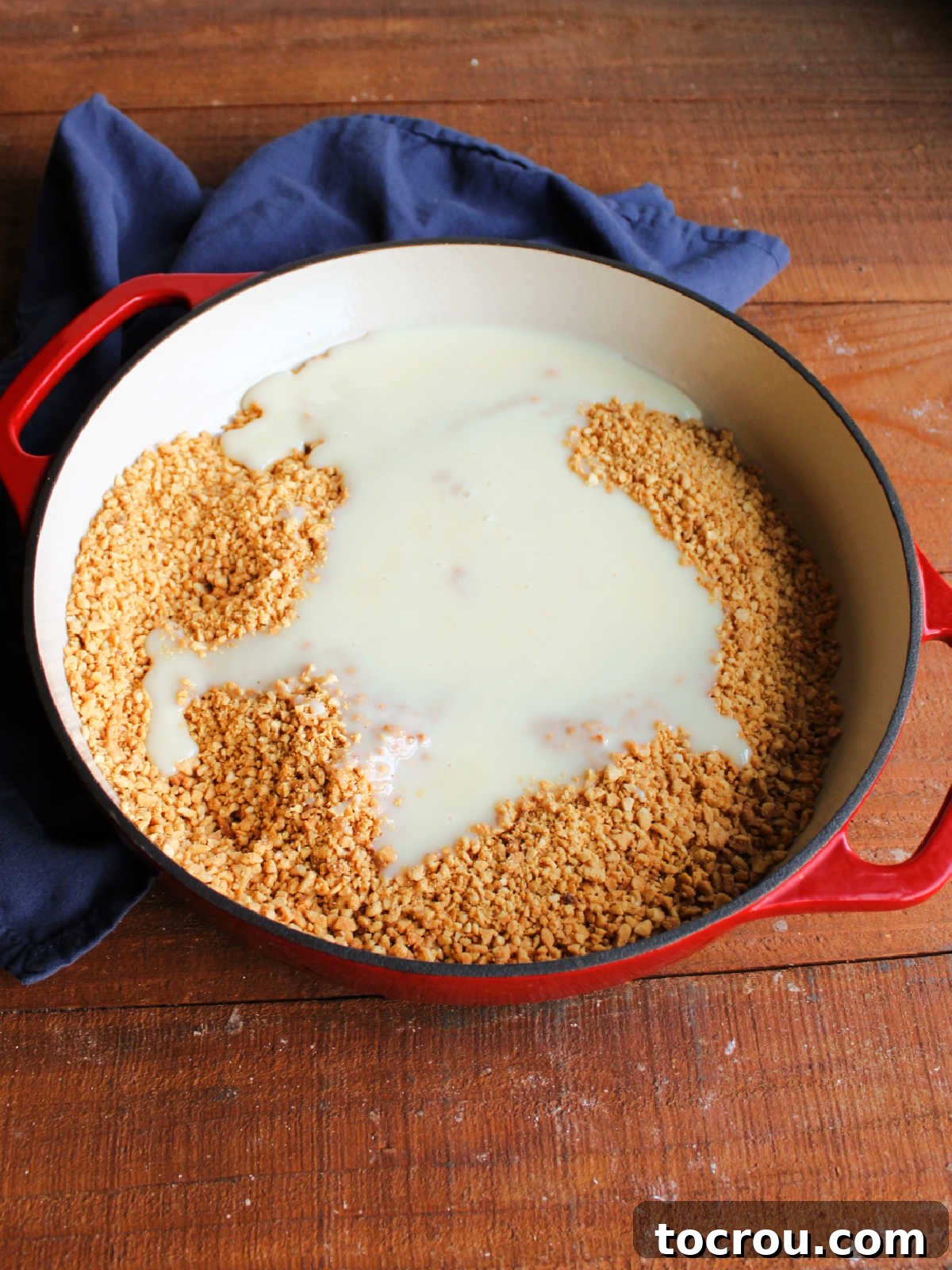 Peanuts and Condensed Milk in Pan Sweetened condensed milk and finely chopped roasted peanuts combined in a saucepan, ready for cooking.