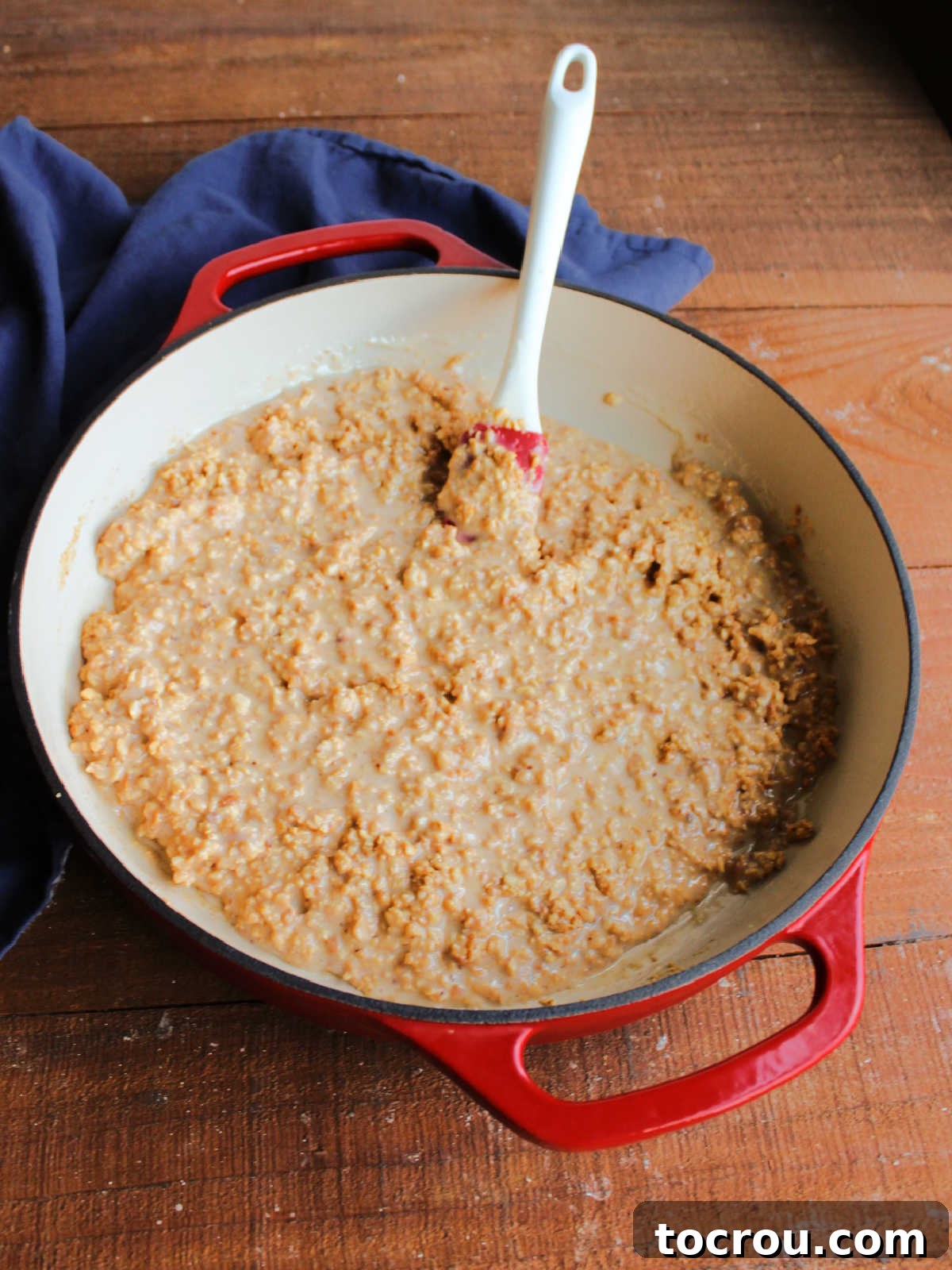 Uncooked Caramel Peanut Mixture Loose mixture of chopped nuts and condensed milk in a pan before cooking, showing a lighter color and runnier texture.