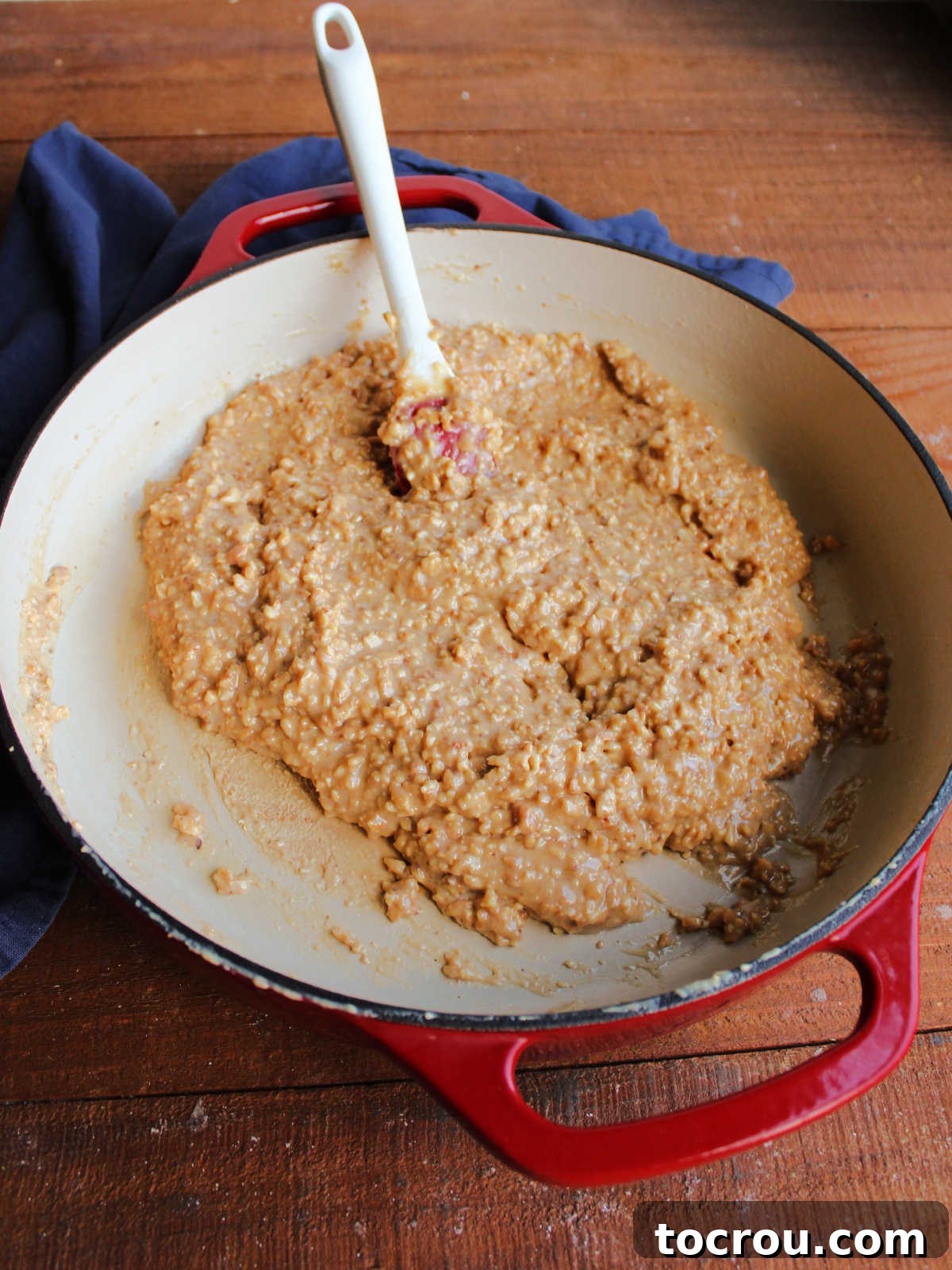 Cooked Caramel Peanut Mixture Cooked caramel peanut mixture in a pan, significantly thicker and darker, indicating it's ready for shaping.