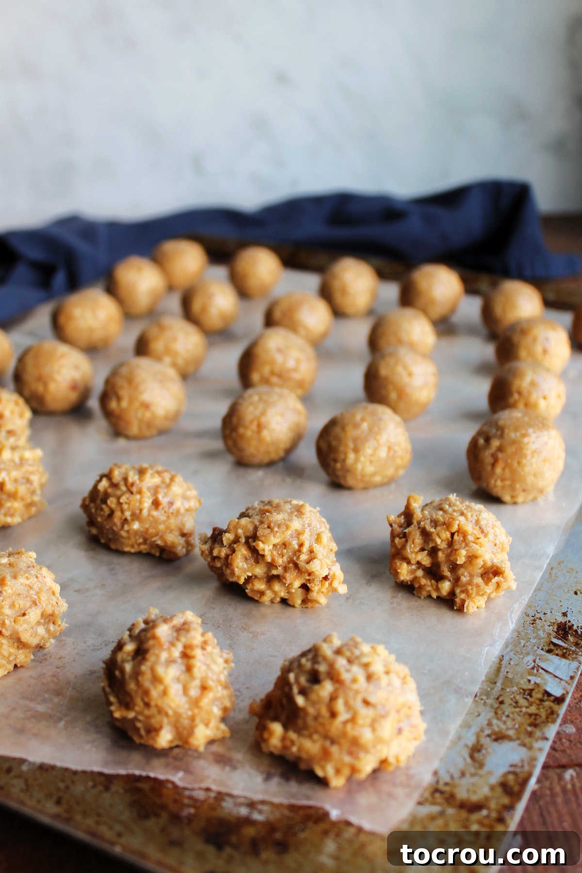 Scooped Caramel Peanut Mixture Scoops of caramel pecan mixture on wax paper, with some already rolled into smooth balls and others retaining the scooped, jagged edges.