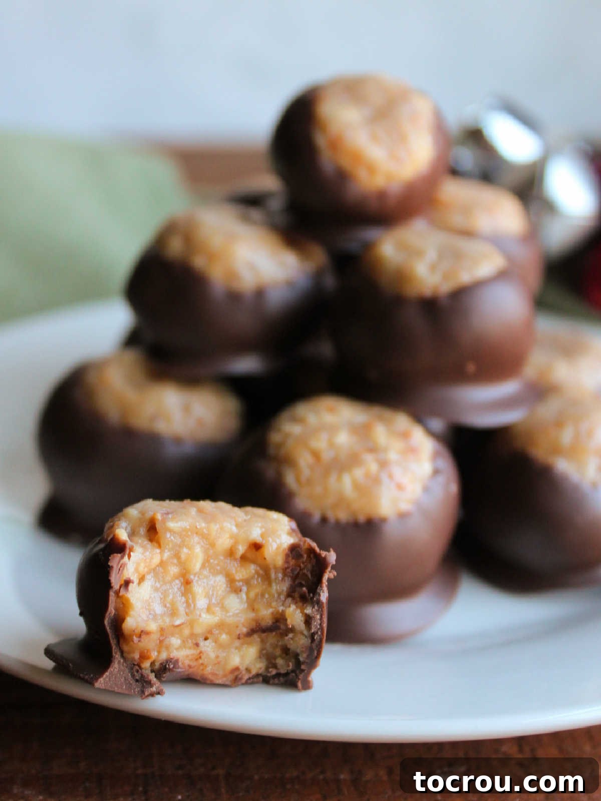 Halved Caramel Peanut Ball A halved caramel peanut ball clearly displaying its soft, chewy, peanut-studded caramel center and the surrounding crisp chocolate shell.