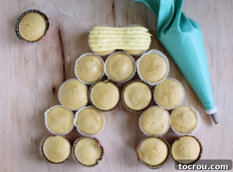 Sun-Kissed Lemon Honey Cream 3 Cupcakes being decorated with a piping bag filled with honey lemon frosting to resemble beehives.