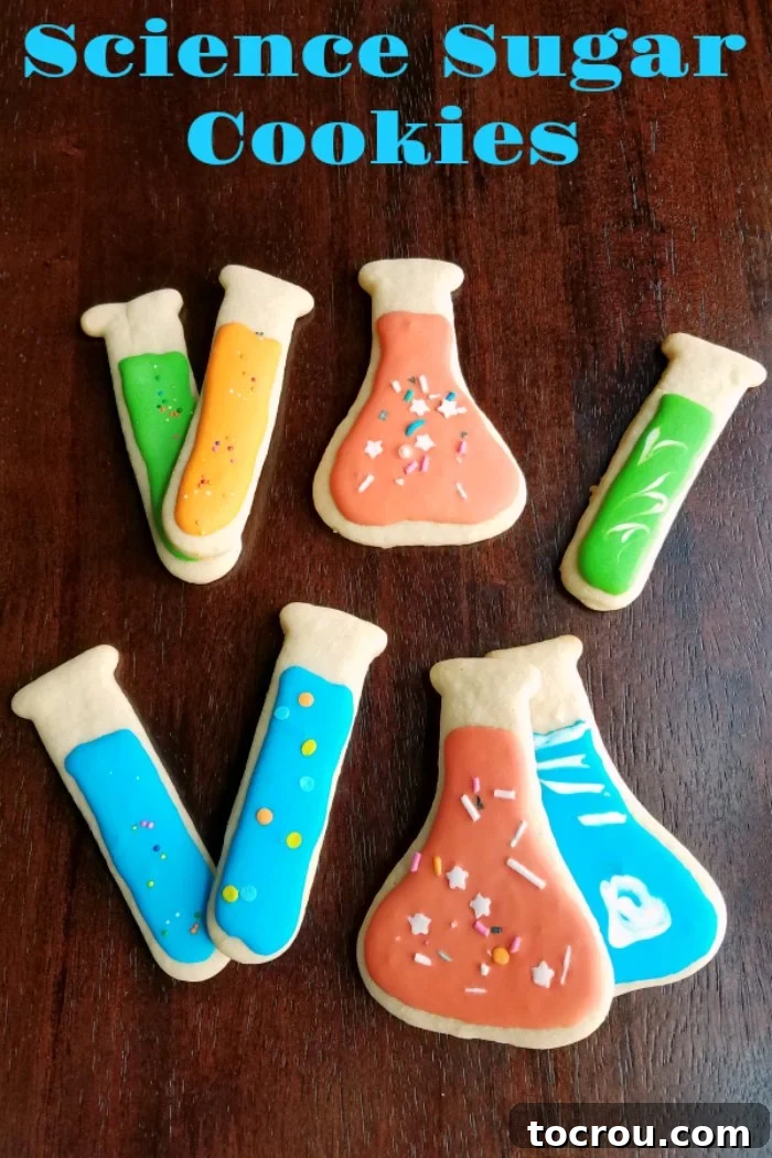 A delightful arrangement of test tube and Erlenmeyer flask shaped sugar cookies, beautifully decorated with colorful royal icing and festive sprinkles.