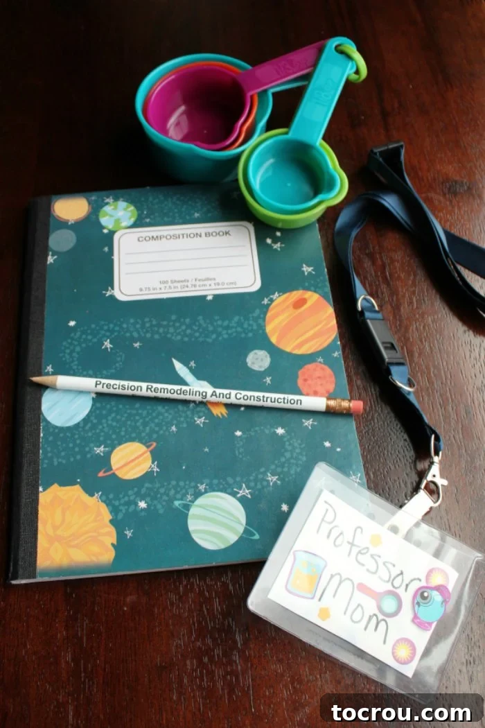 A science kit containing a composition notebook, pencil, name tag, and measuring cups, designed for a science-themed party. Safety glasses are also included but not pictured.
