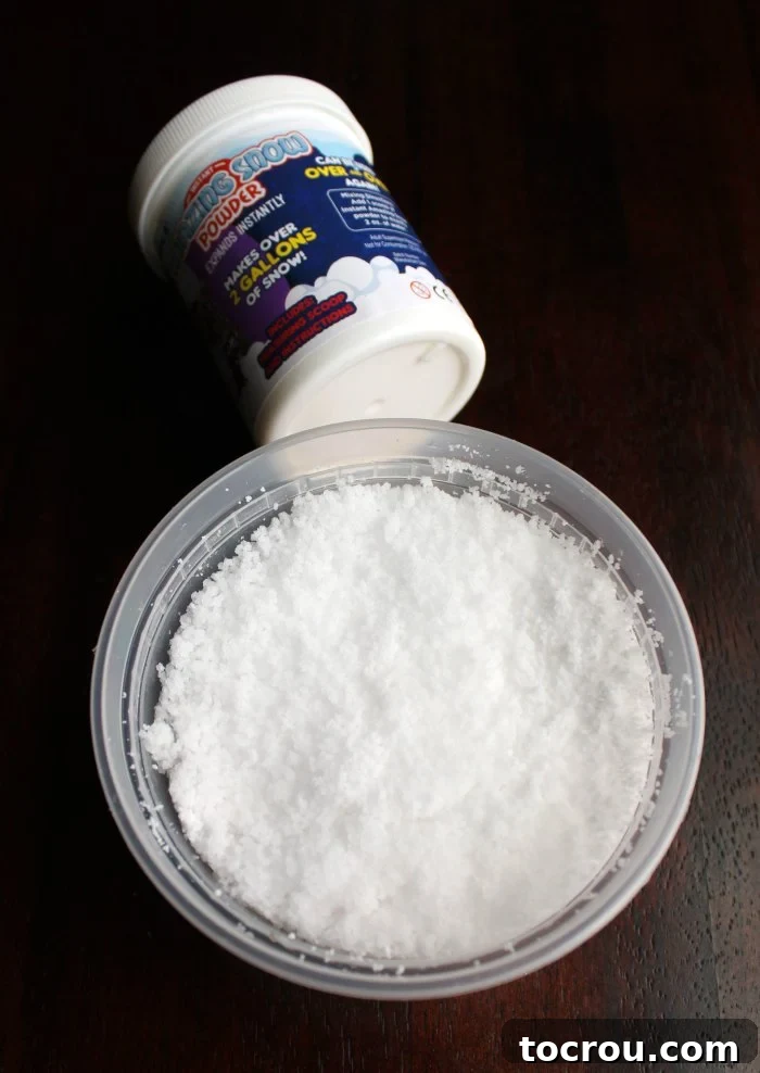 A tub filled with fluffy, artificial play snow, with a container of the snow powder visible in the background.