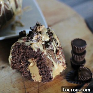 Chocolate Peanut Butter Infused Bundt Cake 4 Slice of chocolate bundt cake filled with peanut butter and topped with a peanut butter drizzle and chopped Reese's peanut butter cups.