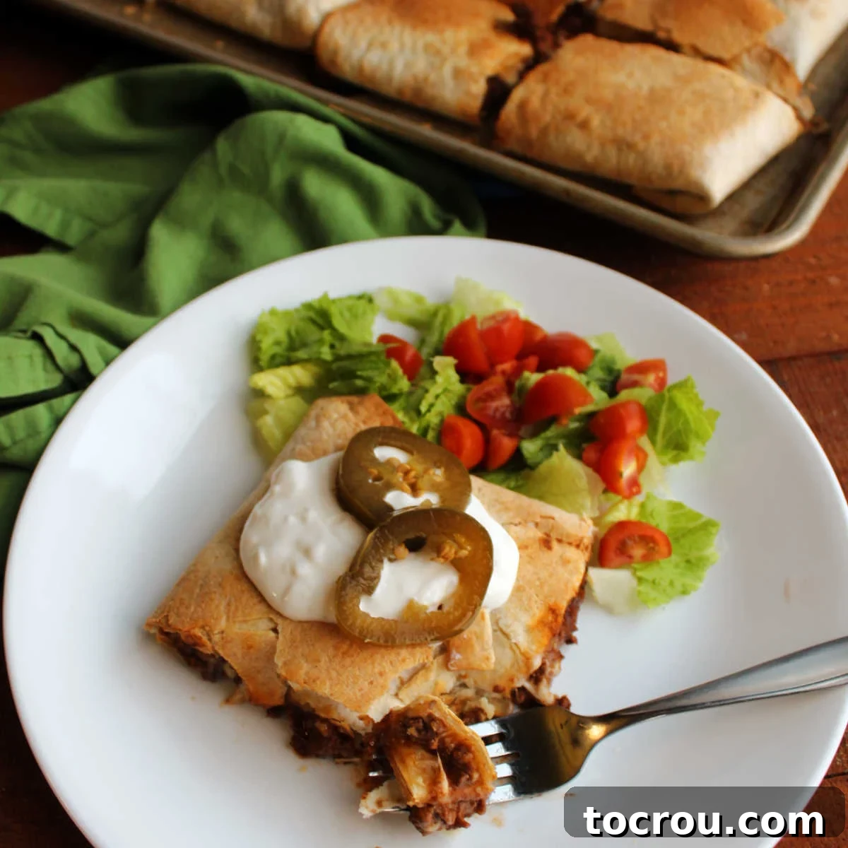 Sheet Pan Quesadilla Bake 11 Plate with piece of sheet pan quesadilla topped with sour cream and jalapenos ready to eat.