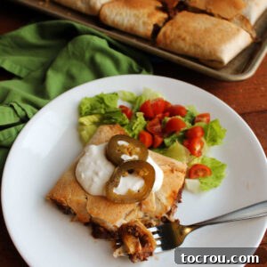 Sheet Pan Quesadilla Bake 12 Plate with piece of sheet pan quesadilla topped with sour cream and jalapenos ready to eat.