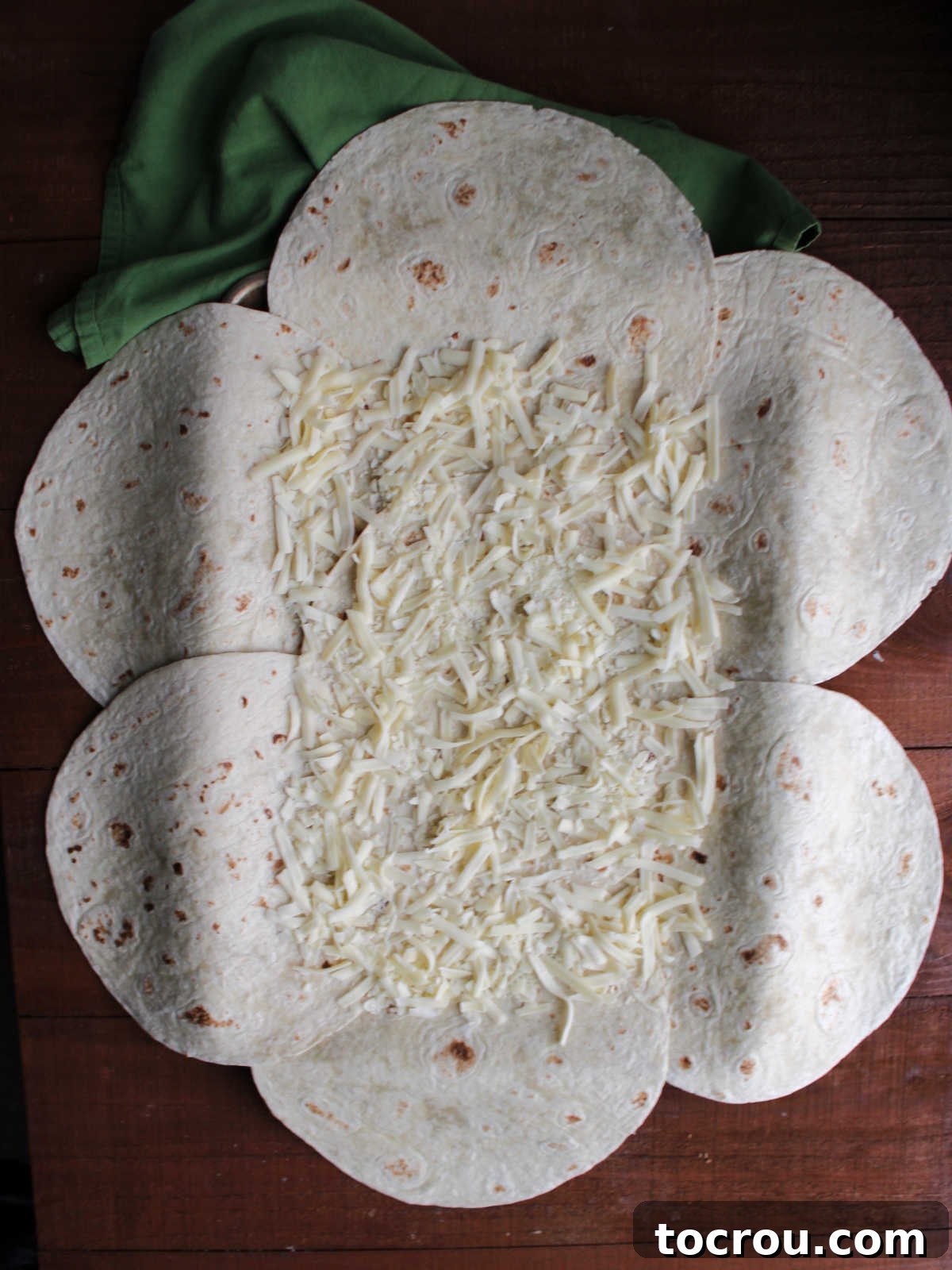 Sheet Pan Quesadilla Bake 5 Sprinkling of white cheddar cheese over bottom layer of tortillas.