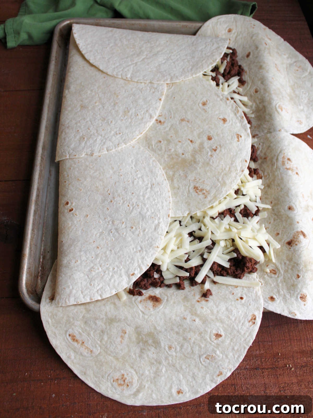 Sheet Pan Quesadilla Bake 7 Wrapping tortillas over fillings, getting it ready to go in the oven.