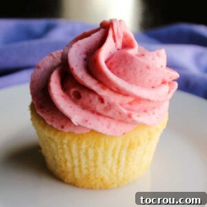 vanilla cupcake topped with a swirl of delicate pink strawberry buttercream.