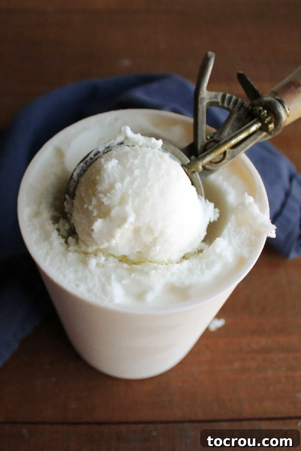 Foolproof Vanilla Ice Cream with Half and Half 7 Ice cream scoop getting frozen vanilla ice cream out of quart storage container.