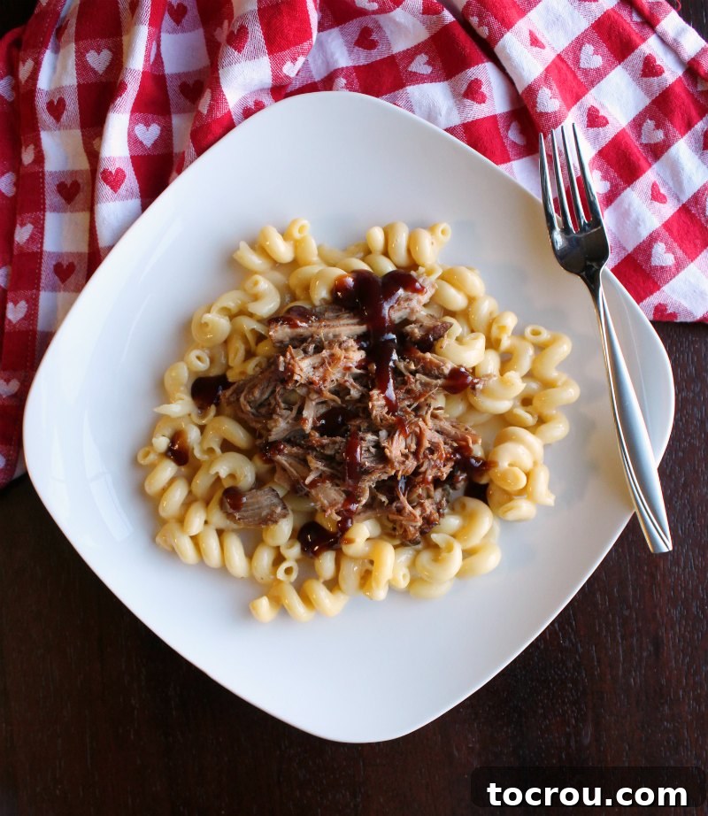 Root Beer Pulled Pork over Mac and Cheese Macaroni and cheese topped generously with root beer pulled pork and a drizzle of BBQ sauce.