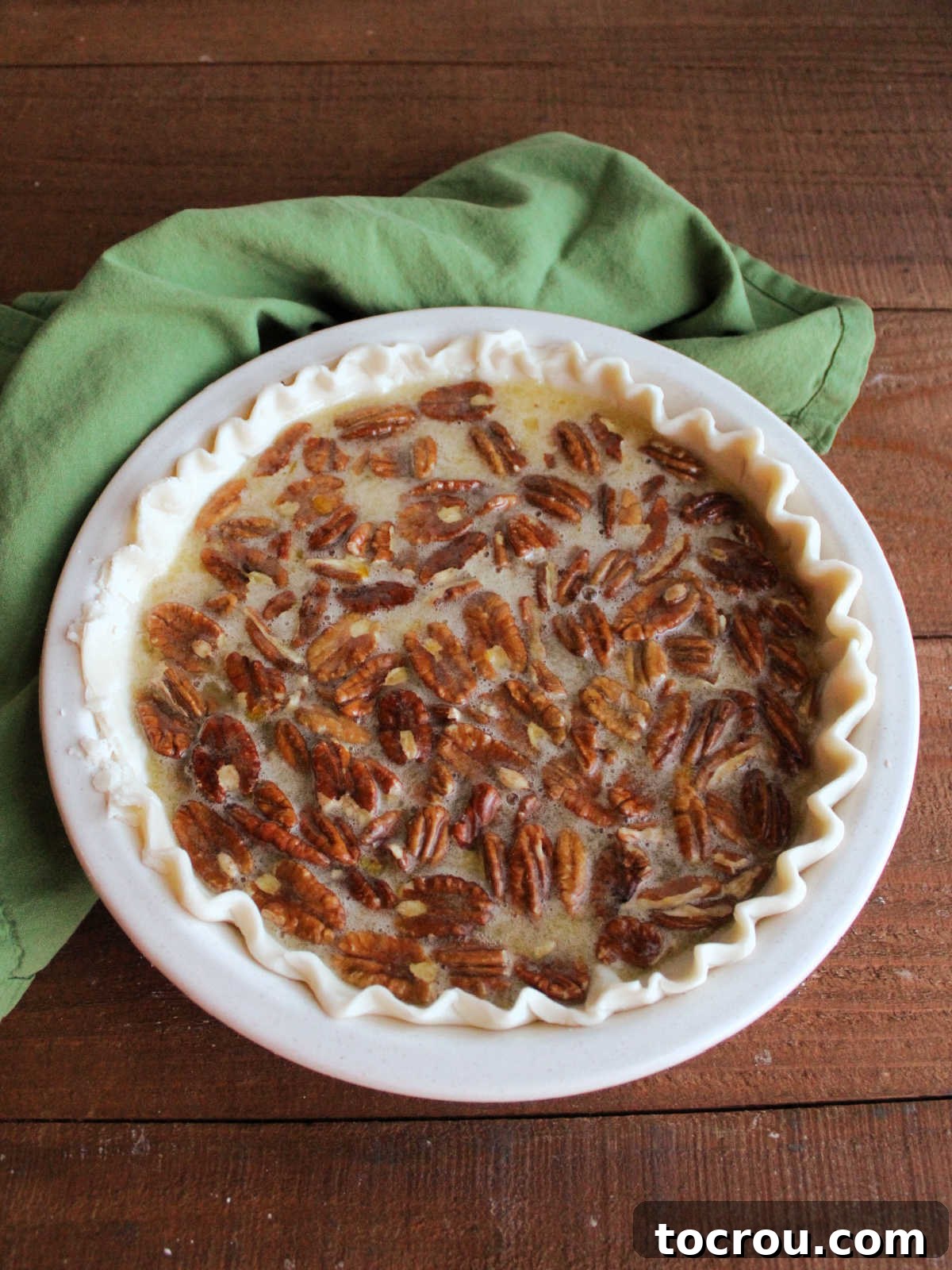 Timeless Pecan Perfection 5 Pie crust filled with gooey pecan pie filing, ready to go in the oven.