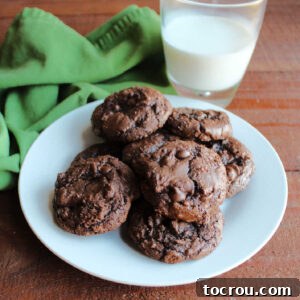 Plate of rich chocolaty brownie mix cookies next to glass of milk.