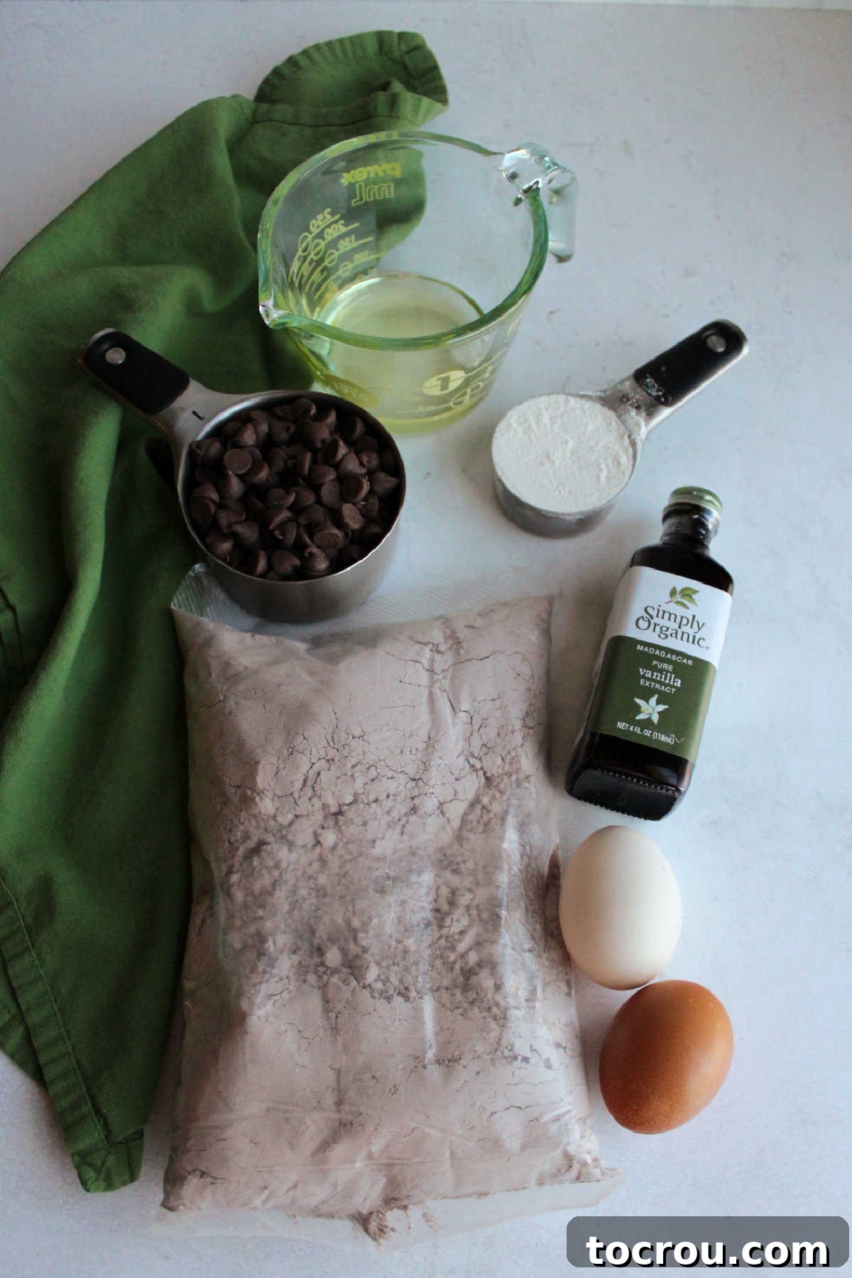 One-Bowl Brownie Cookies 3 Essential ingredients for easy brownie mix cookies laid out: family-size brownie mix, eggs, vanilla extract, all-purpose flour, chocolate chips, and vegetable oil.