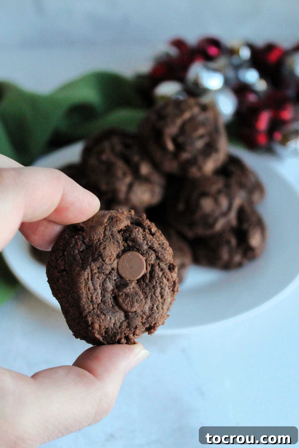 One-Bowl Brownie Cookies 10 A hand holding a perfectly baked double chocolate brownie mix cookie, showcasing its enticing crackled surface.