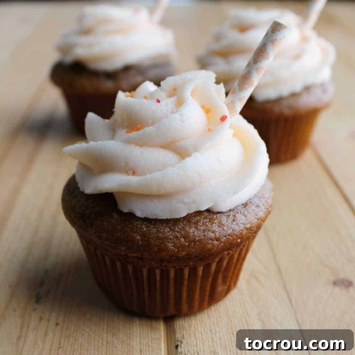 Sweet tea cupcakes with peach buttercream and paper straw decorations, embodying the taste of summer.