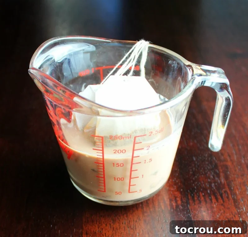Tea bags steeping in milk for making sweet tea cupcakes, showing the infusion process.