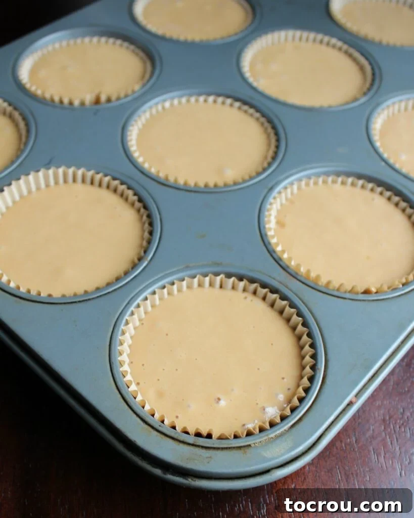 Sweet tea cake batter in a cupcake tin, ready to be baked into delicious treats.