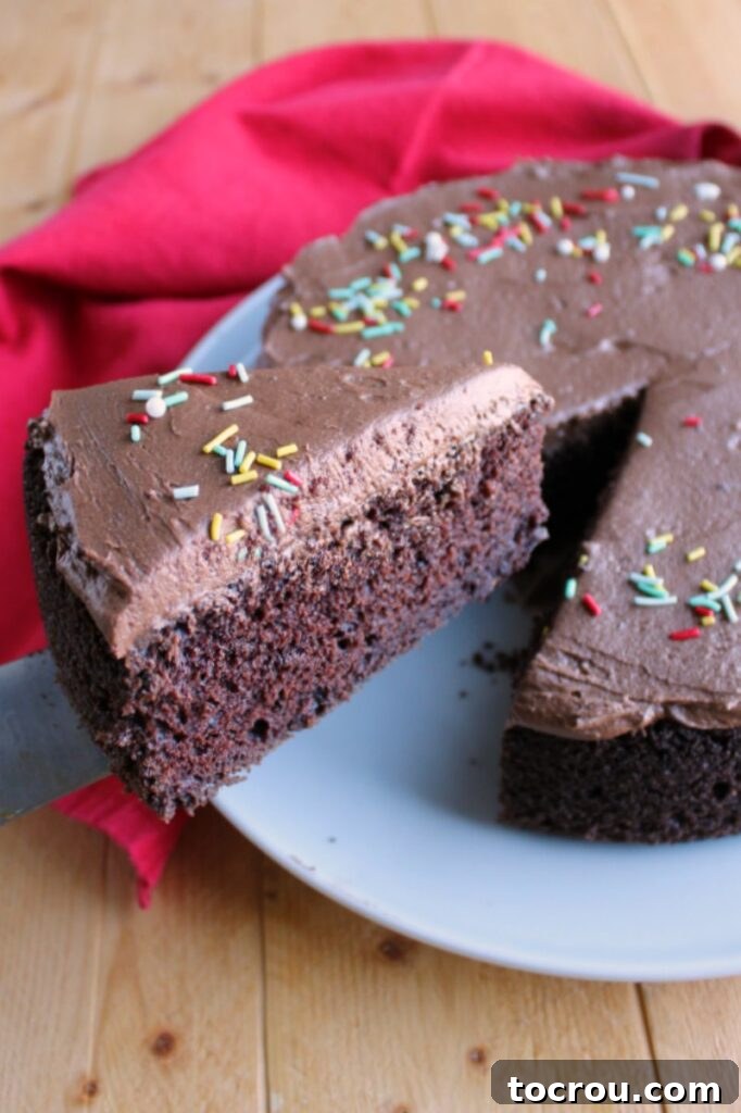 Chocolate Velvet Indulgence 4 A server lifting the first perfect slice of chocolate mayonnaise cake from the baking pan, showcasing its moist interior.