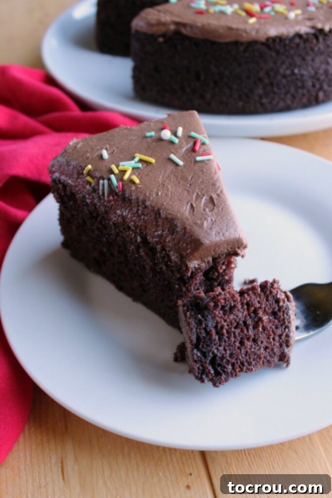Chocolate Velvet Indulgence 5 A close-up shot of a fork with a perfect bite of moist chocolate mayonnaise cake, showcasing its rich texture and delicious frosting.