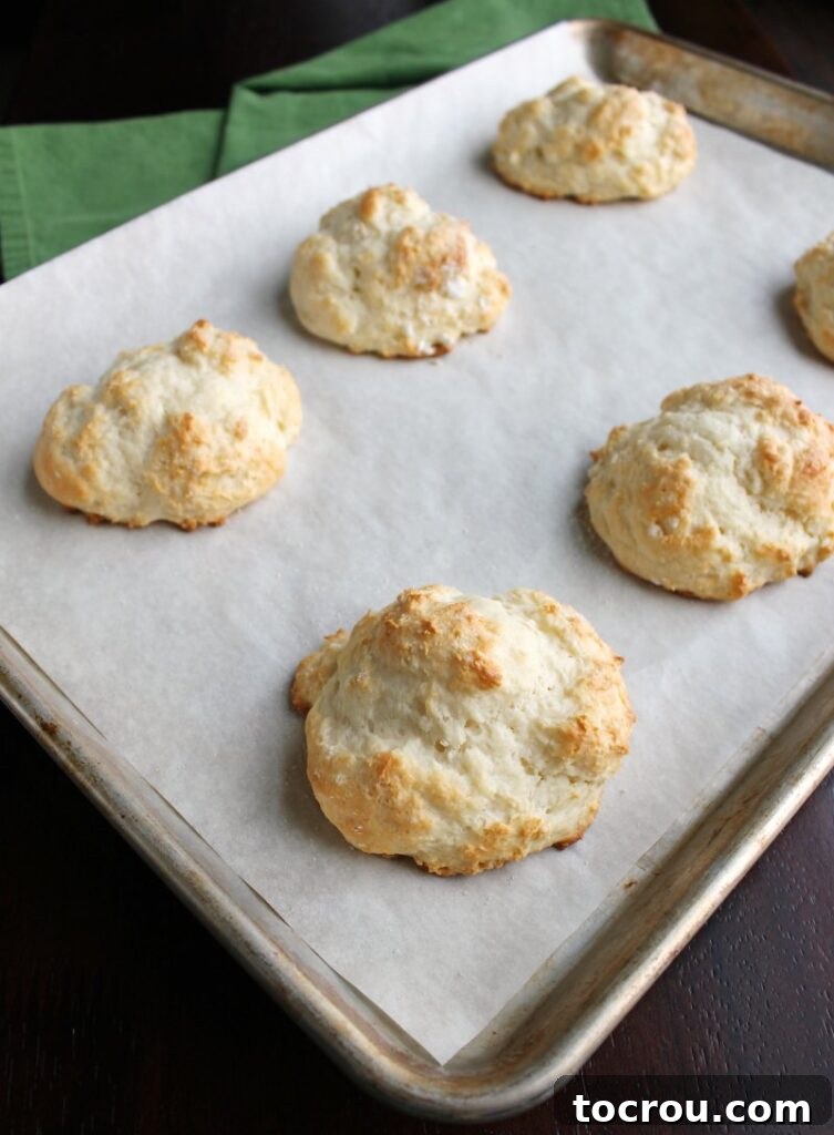 Tray of golden yogurt drop biscuits fresh from the oven, showing their perfectly browned tops and soft texture.