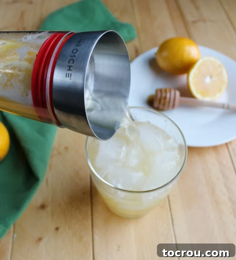Bees' Kissed Lemonade 6 Pouring a glass of homemade honey lemonade, ready to be enjoyed.