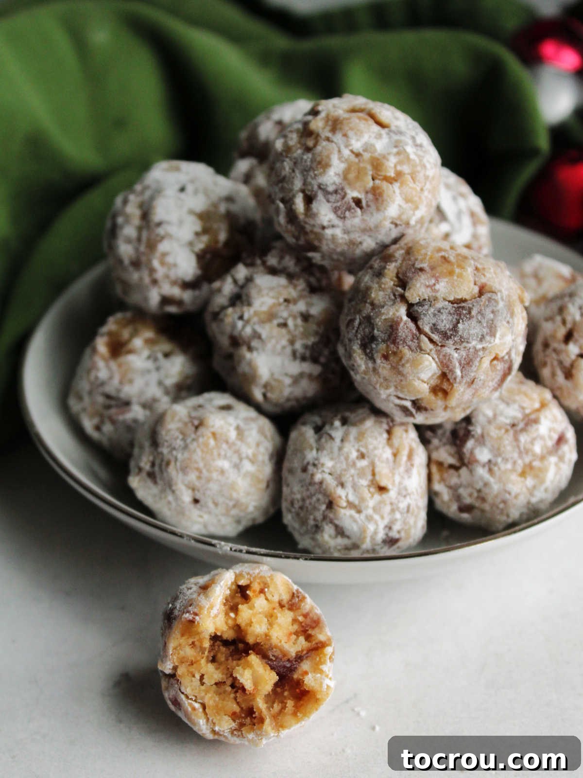 Grandma's Date Treats 11 Small bowl of classic date balls coated in powdered sugar, ready to eat.