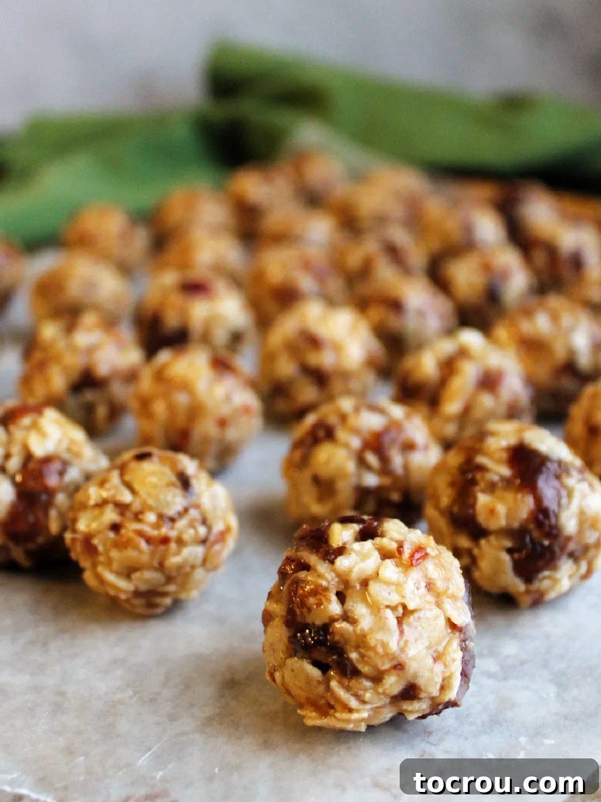 Grandma's Date Treats 8 Portions of date ball mixture rolled into balls on a sheet of wax paper.