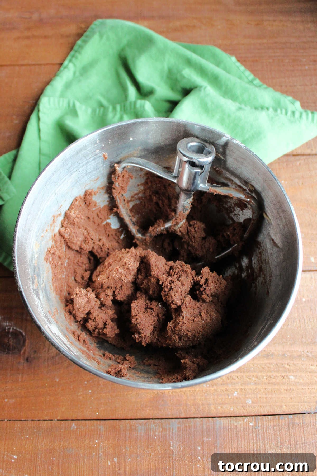 Peppermint Kissed Chocolate Blooms 5 Mixer bowl with paddle attachment and soft chocolate cookie dough inside, showcasing the rich texture.