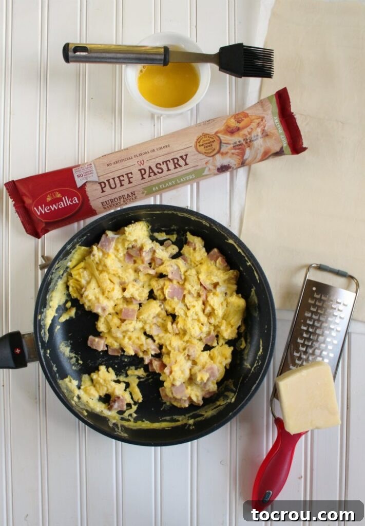 puff pastry, scrambled eggs and cheese ready to be folded into pockets and baked.