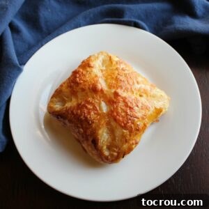 golden brown ham egg and cheese hand pie on plate.