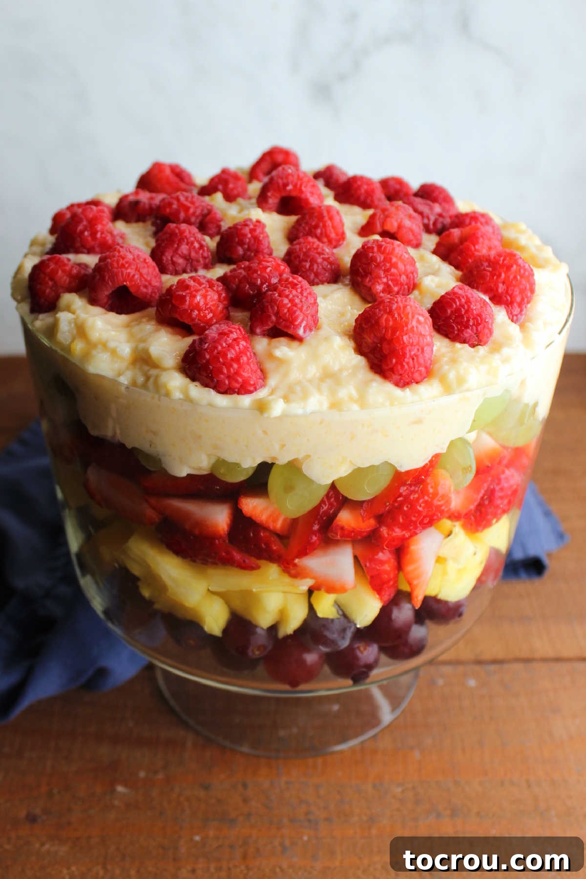 Fresh, plump raspberries delicately scattered on top of the creamy pudding layer, providing a beautiful, colorful finish to the layered fruit salad.