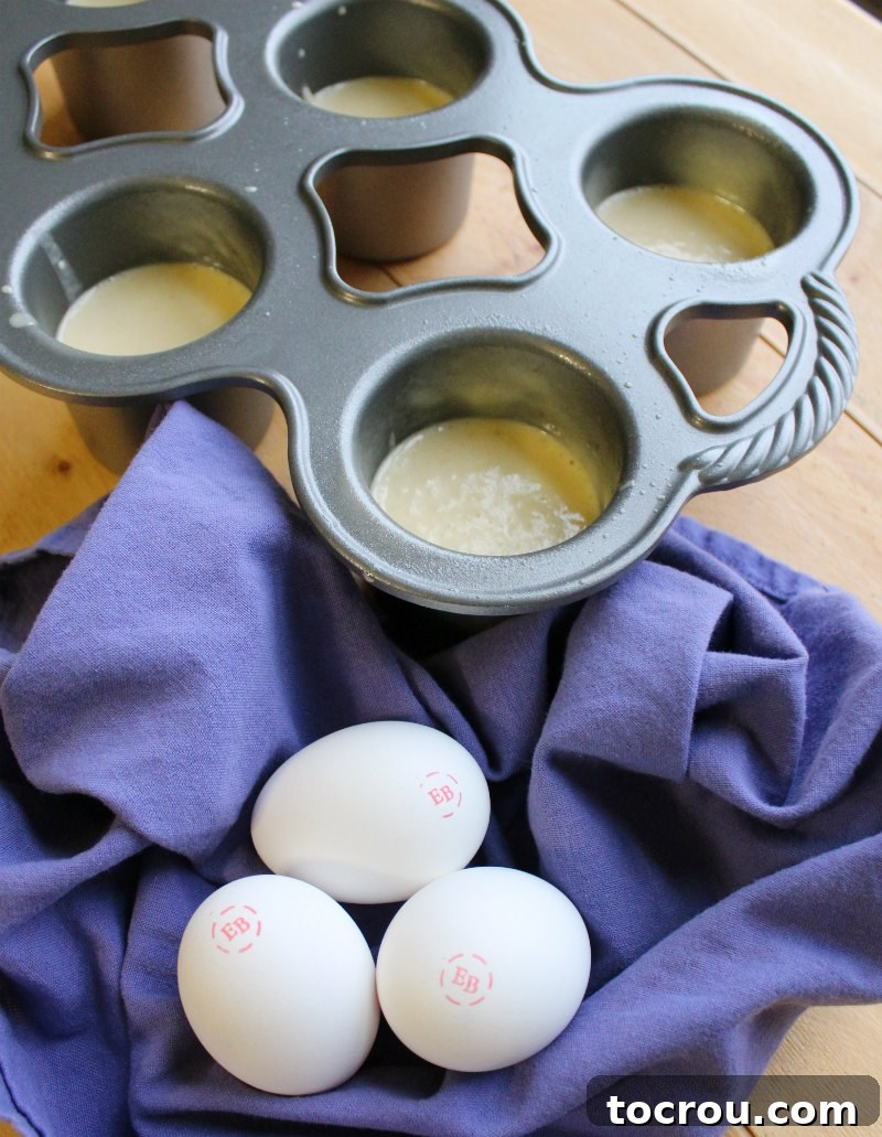 Popover batter in a mixing bowl next to fresh eggs, ready for preparation.