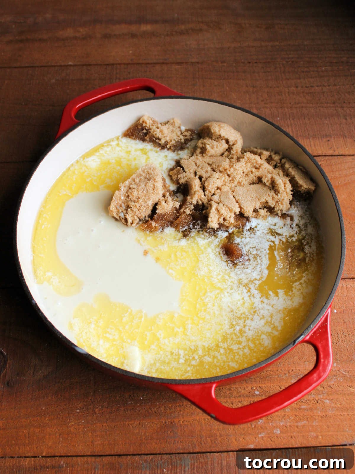 Cast iron pan with melted butter, corn syrup, sweetened condensed milk, and brown sugar inside to be made into caramel.