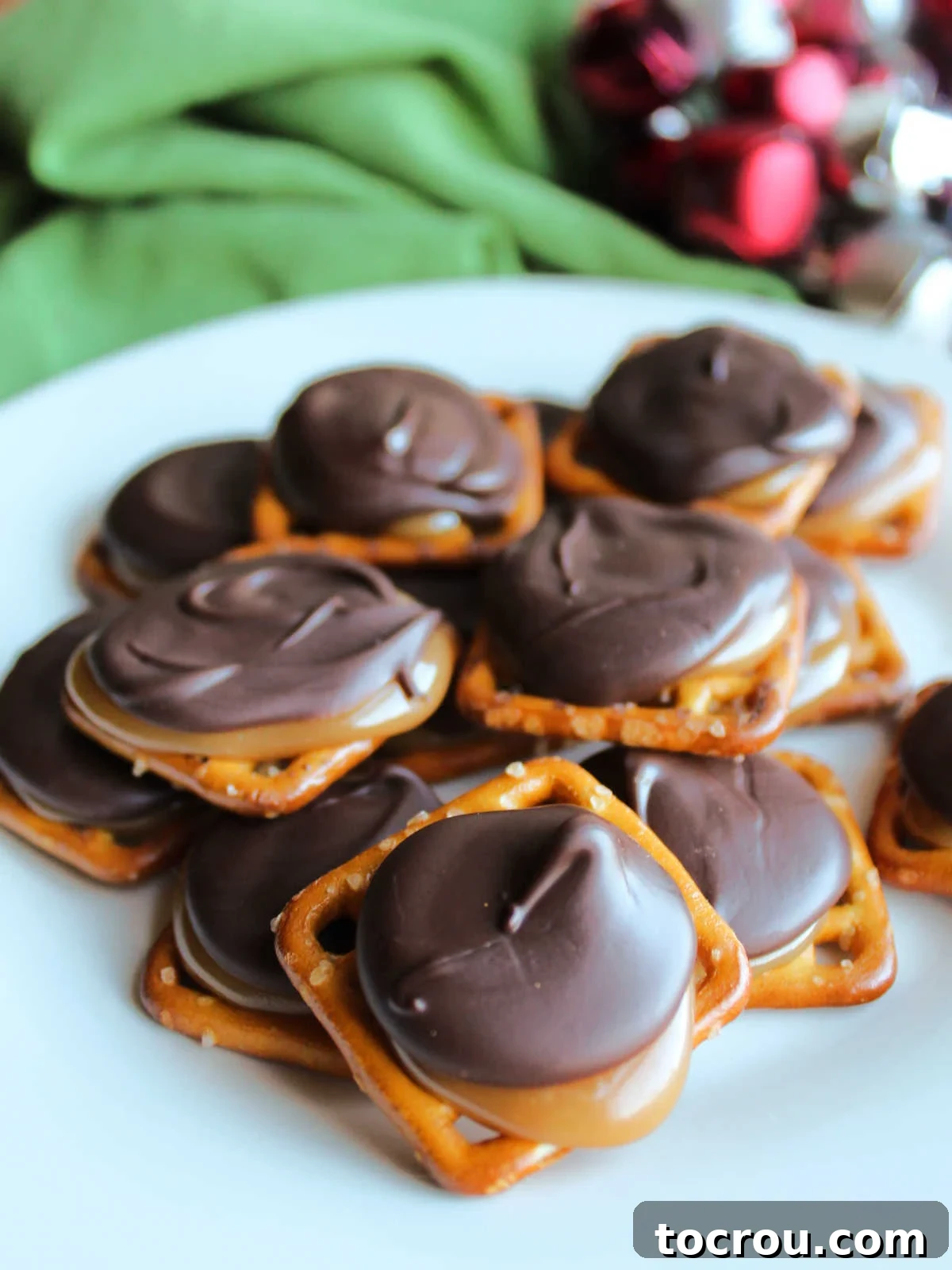 Plate of faux turtles made out of pretzels, homemade caramel, and chocolate, ready to eat.