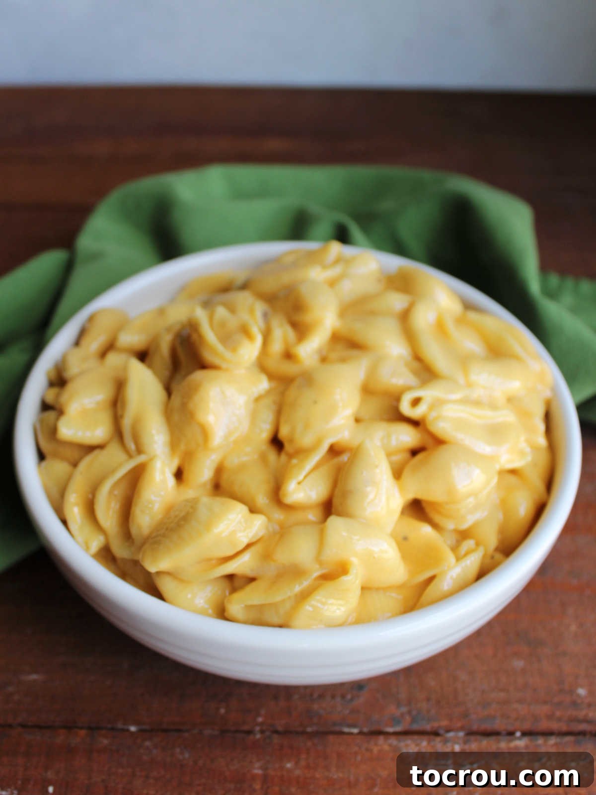 Serving bowl filled with creamy homemade velveeta mac and cheese with shell pasta. 