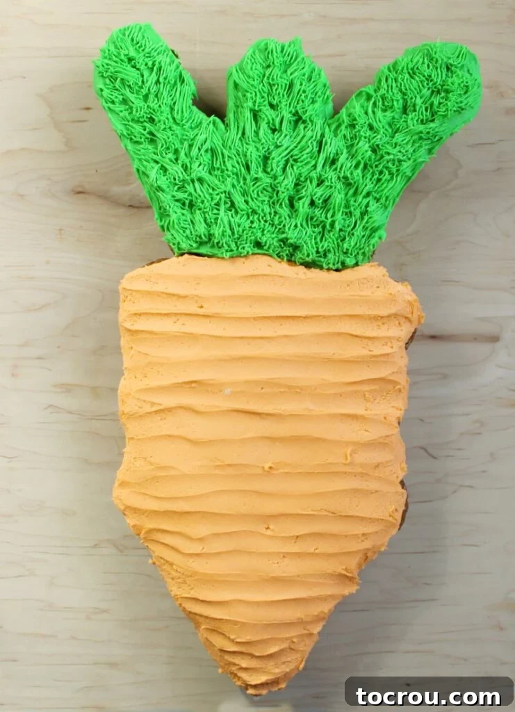 Pull-Apart Carrot Cake: A Cupcake Masterpiece 2 A beautifully decorated carrot cupcake pull-apart cake, featuring a vibrant orange carrot body made from frosted cupcakes and lush green fronds on top, perfectly arranged and ready for serving at a festive event.