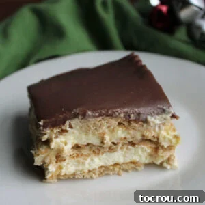 No-Bake Eclair Cake Slice Slice of eclair cake with vanilla pudding mixture, graham crackers, and fudge icing.