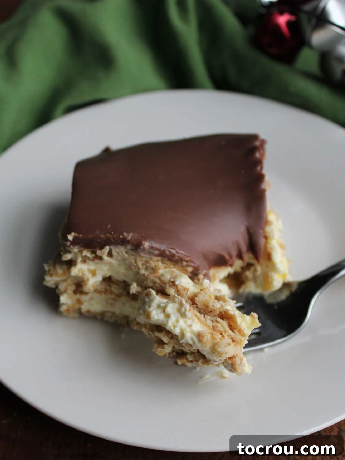 Ready to Enjoy Eclair Cake A delightful bite of no-bake eclair cake poised on a fork, ready to be savored, revealing its soft layers and rich chocolate.