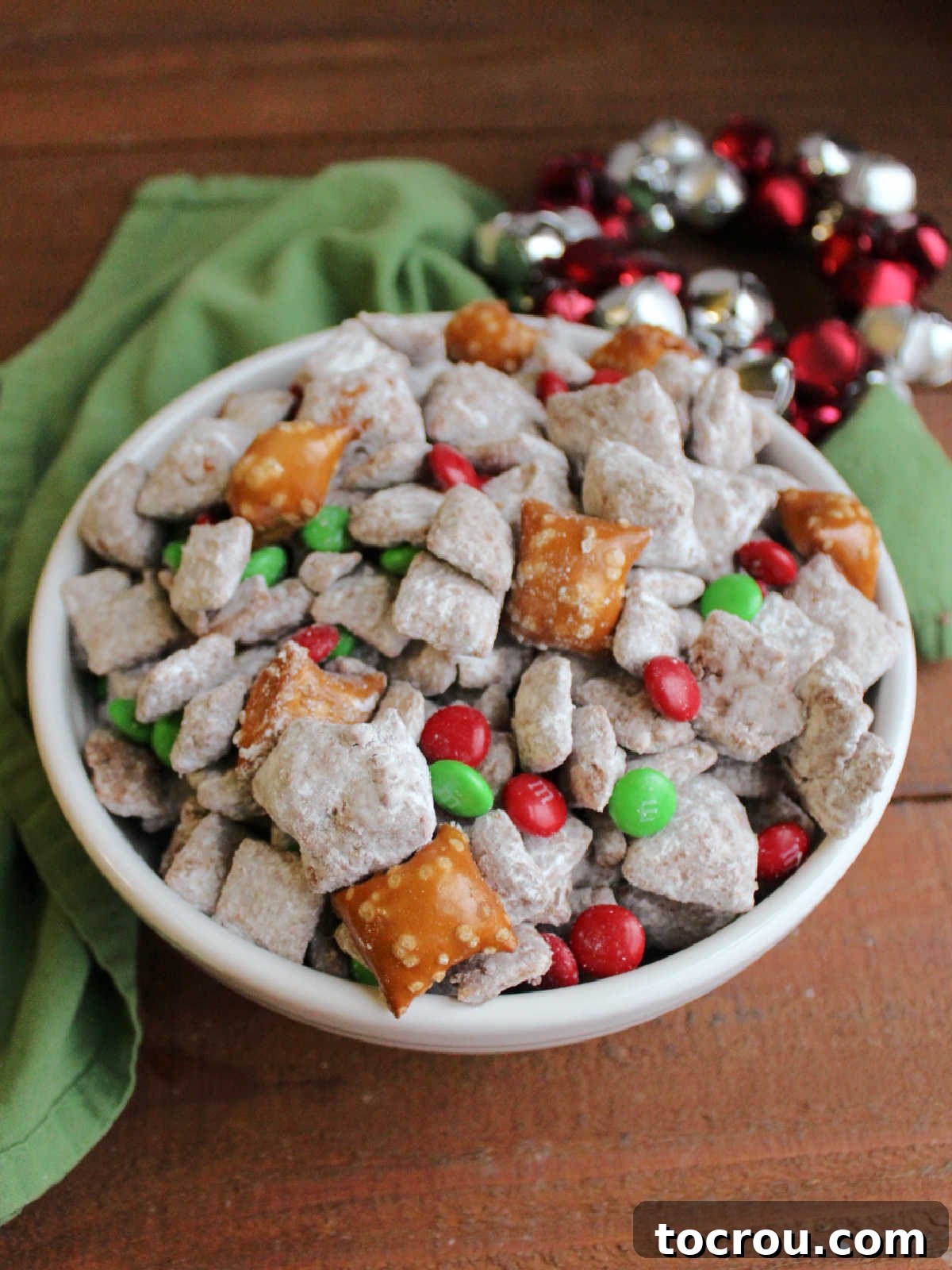 Loaded puppy chow with peanut butter filled pretzels and holiday M&Ms inside, ready to eat.
