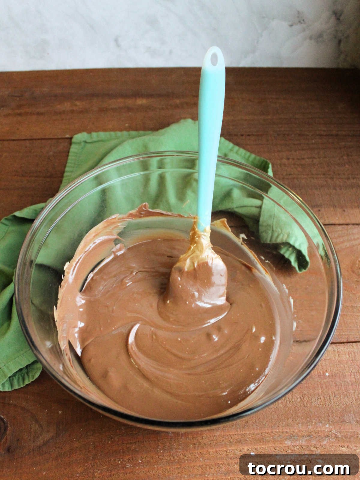 Chocolate chips and peanut butter melted together in large glass bowl.